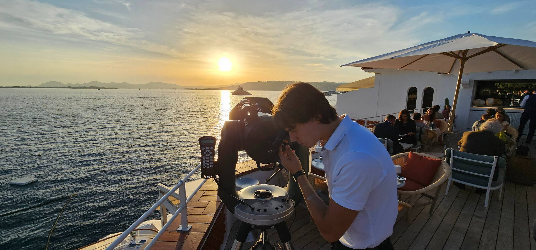 Astronomy telescope on a terrace overlooking the sea at sunset